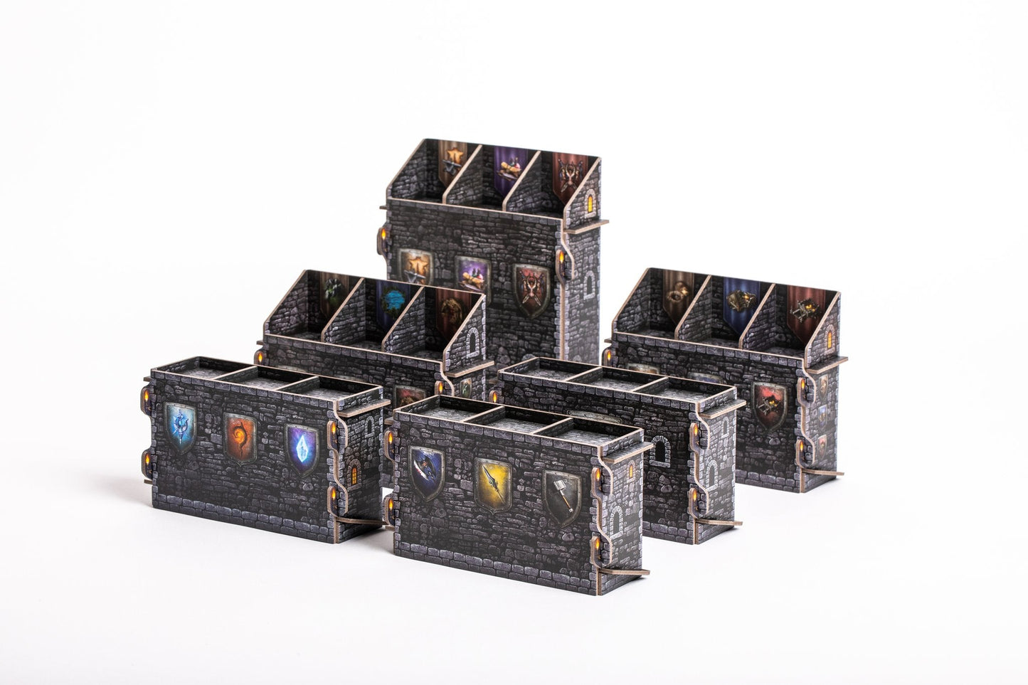 Six small, black, stone-textured Euthia: Torment of Resurrection Organizer boxes by DIEA Games, each with colored shield symbols and dividers, are neatly arranged on white—perfect for stylishly organizing your board game collection.