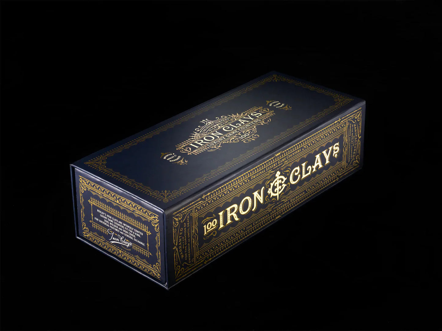 A rectangular, navy blue box with gold designs displays "Iron Clays 100 Printed Box with Chips" by Roxley Games on the side and top, hinting at premium poker chips inside and designed for euro style games.