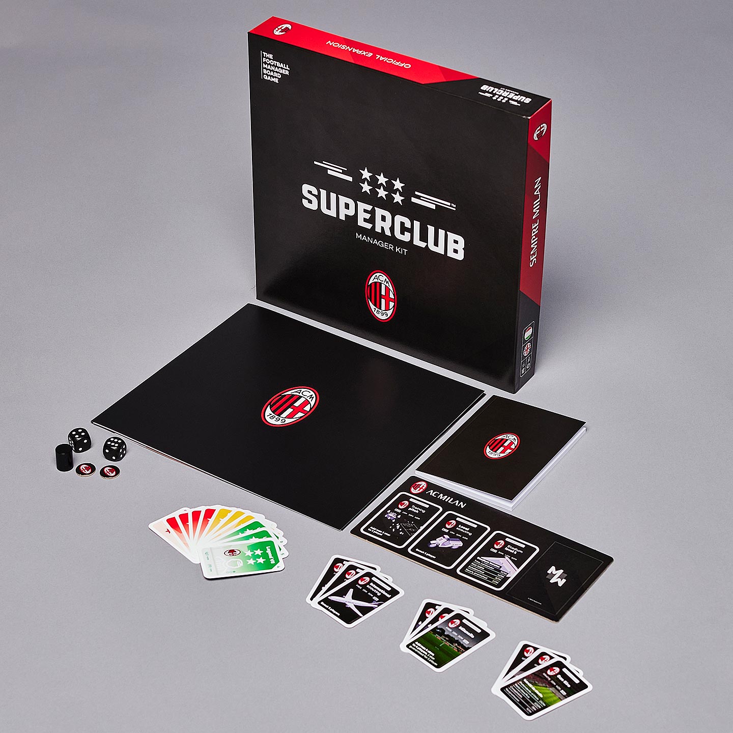 The Superclub: AC Milan Manager Kit by Superclub includes a game board, cards, dice, tokens, and an instruction booklet with an AC Milan logo and manager folder, all neatly arranged on a gray surface.