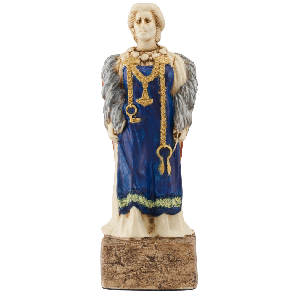 The Studio Anne Carlton Games Celtic & Viking Hand-painted Chess Pieces Set features a ceramic figure in a blue dress with gold trim, gold jewelry, and a gray fur stole on a textured base—an ideal addition to your unique chess set.
