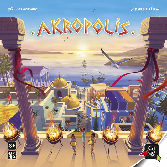Illustrated cover for Akropolis by Gigamic, featuring a lively ancient Greek city at sunset with ships, domed buildings, columns, and two soldiers approaching the city. The title AKROPOLIS appears above in this immersive board game.