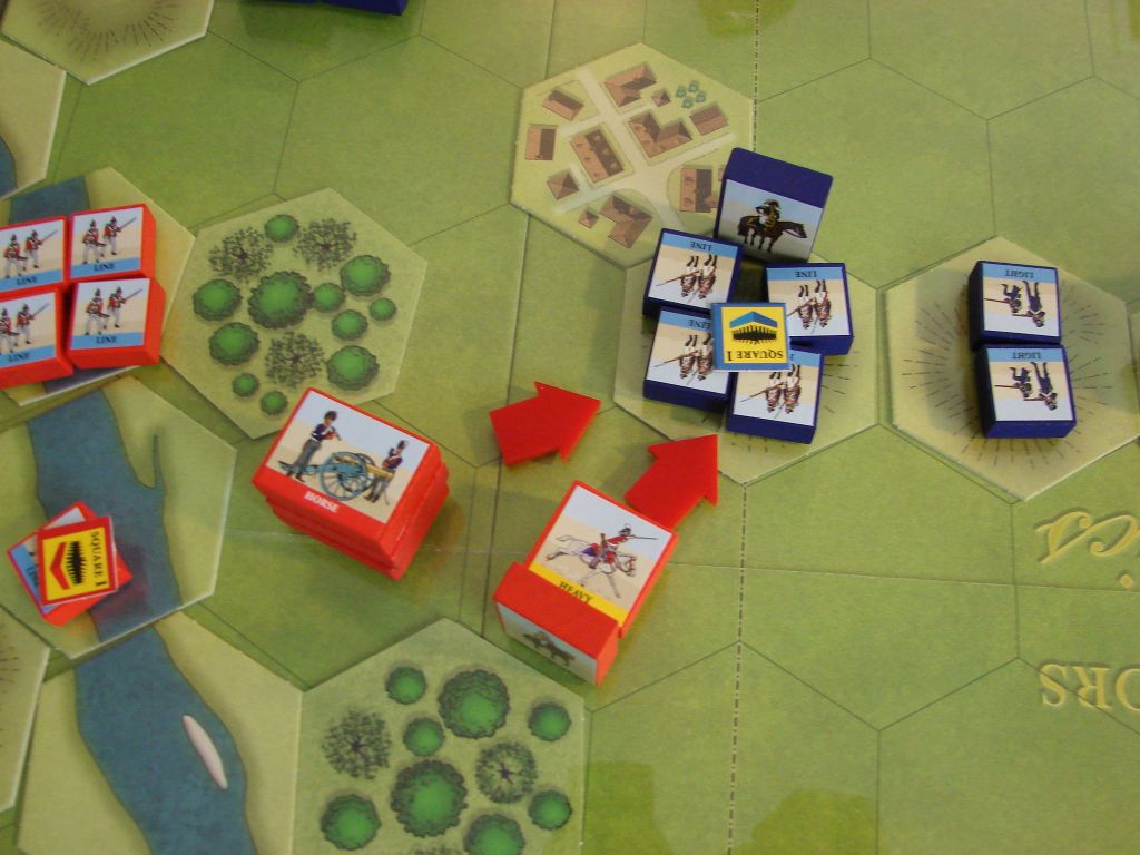 A close-up of Commands & Colors: Napoleonics by GMT Games reveals illustrated hex tiles and colored blocks with horse and soldier icons, red arrows for attacks, and terrain like forests, rivers, and villages that set this Napoleonic wargame’s scene.