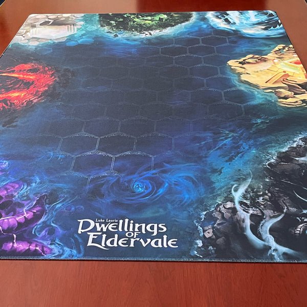 The Dwellings of Eldervale: Limited Edition Game Mat by Breaking Games measures 36"x48", features a hexagonal grid and vivid elemental art—fire, water, earth, and lightning—along the edges, perfect for enhancing your fantasy gameplay.