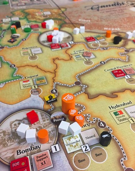 A close-up of the Gandhi: The Decolonization of British India, 1917–1947 map by GMT Games shows regions like Gujarat, Bombay, and Hyderabad with colorful cubes and tokens marking gameplay in this COIN Series strategy game.