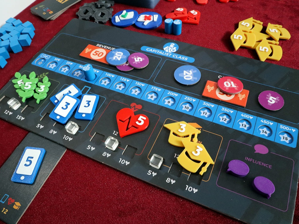 A close-up of Hegemony - 3D Upgraded Components by Game Maker Team, showing colorful leaf, phone, apple, and bird tokens with numbers and symbols in play on a “Capitalist Class” board atop a red tabletop.