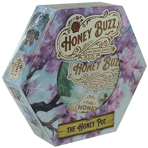 The Honey Buzz Honey Pot Expansion by Elf Creek Games comes in a hexagonal box featuring floral art with blossoms and bees, vintage-style text, and highlights its included nectar jar module for the Honey Buzz game.
