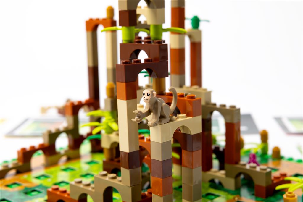 The LEGO: Monkey Palace (NL/FR) by Dotted Games features a toy monkey atop a brown and tan jungle palace, with green and yellow pieces as plants—ideal for fans of stenen en bananen adventures.