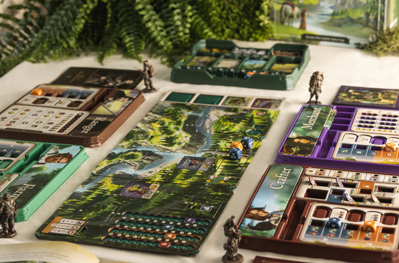 Mythwind (Damaged) by Open Owl Studios, a colorful cooperative board game with a fantasy forest theme, is set on a table with character miniatures, dice, cards, and player boards surrounded by lush green plants.