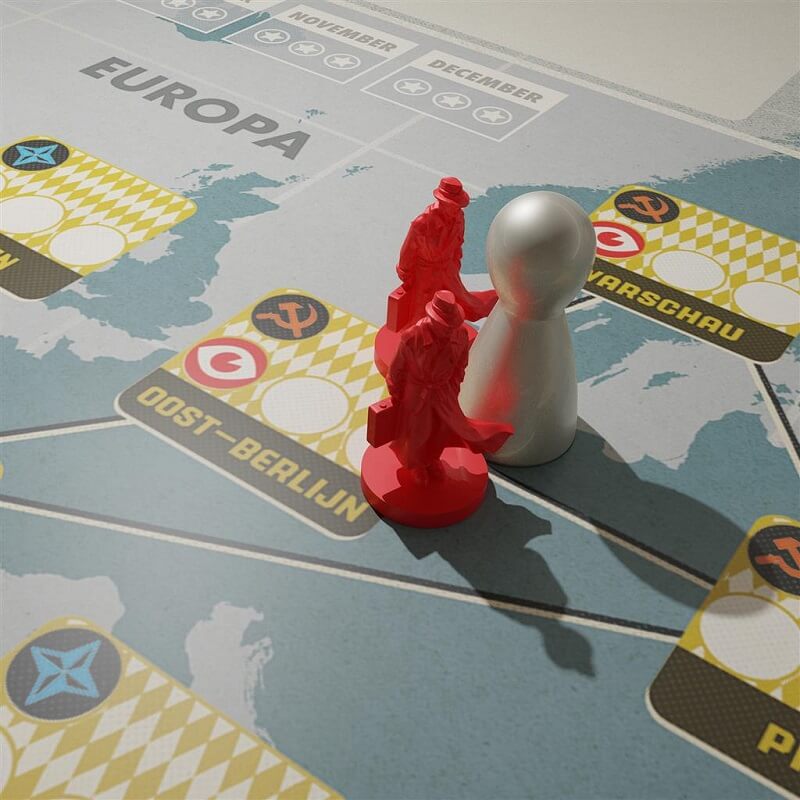 A close-up of the Europa map from Pandemic Legacy Seizoen 0 NL by Z-Man Games shows two red spy figures and a silver pawn on Oost Berlijn, which is connected to other cities such as Warschau.