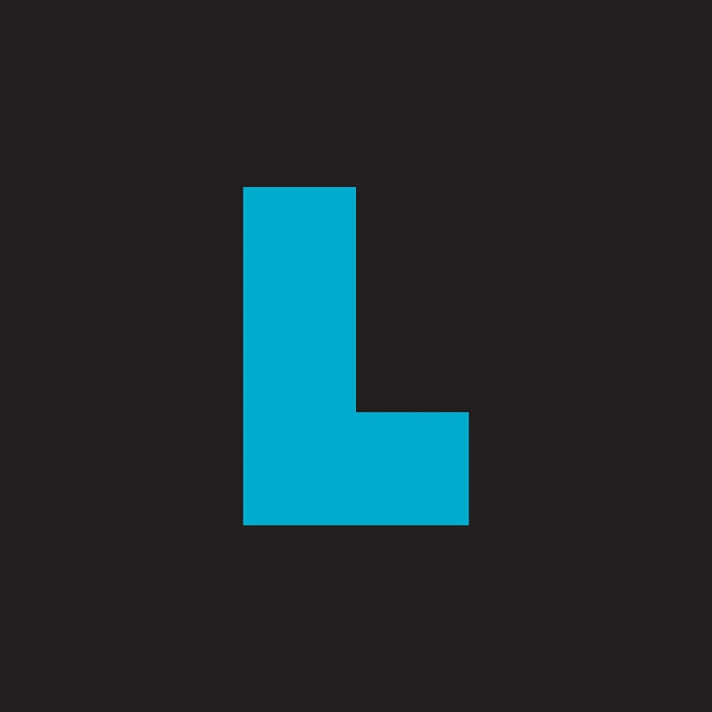 A bold, blue capital letter L, inspired by tile-matching games, is centered on a solid black background for Project L EN/DE/FR by Boardcubator.
