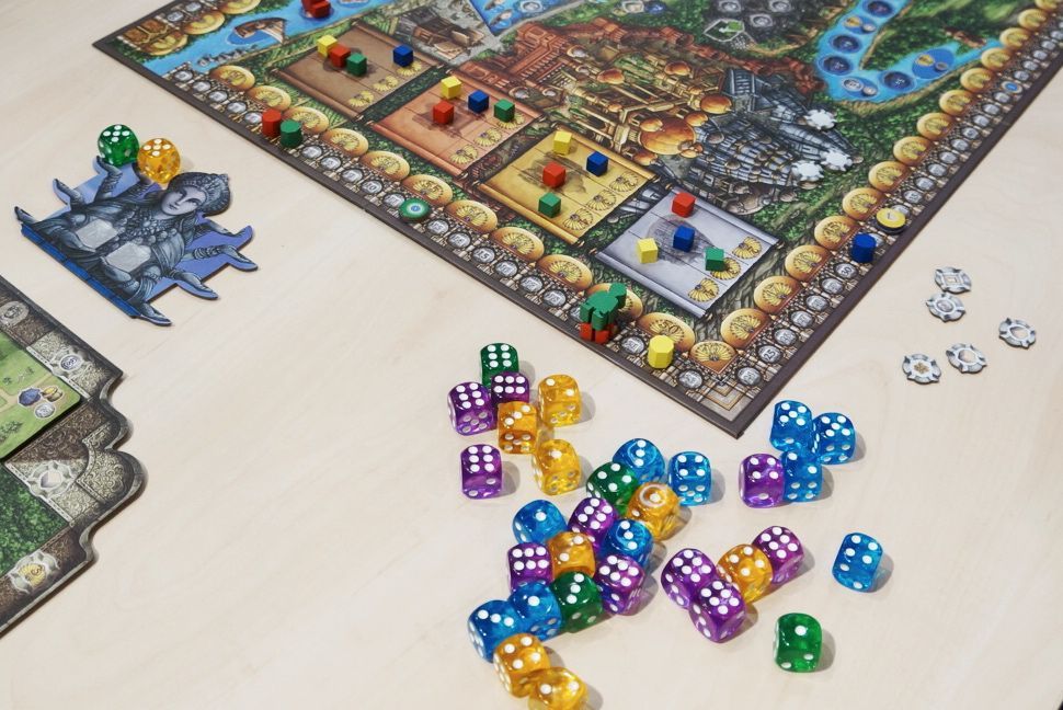 The Huch Rajas of the Ganges - EN/DE/FR board game features a vibrant 16th-century India-inspired board, tokens, character cards, and colorful dice arranged on a light wooden table.