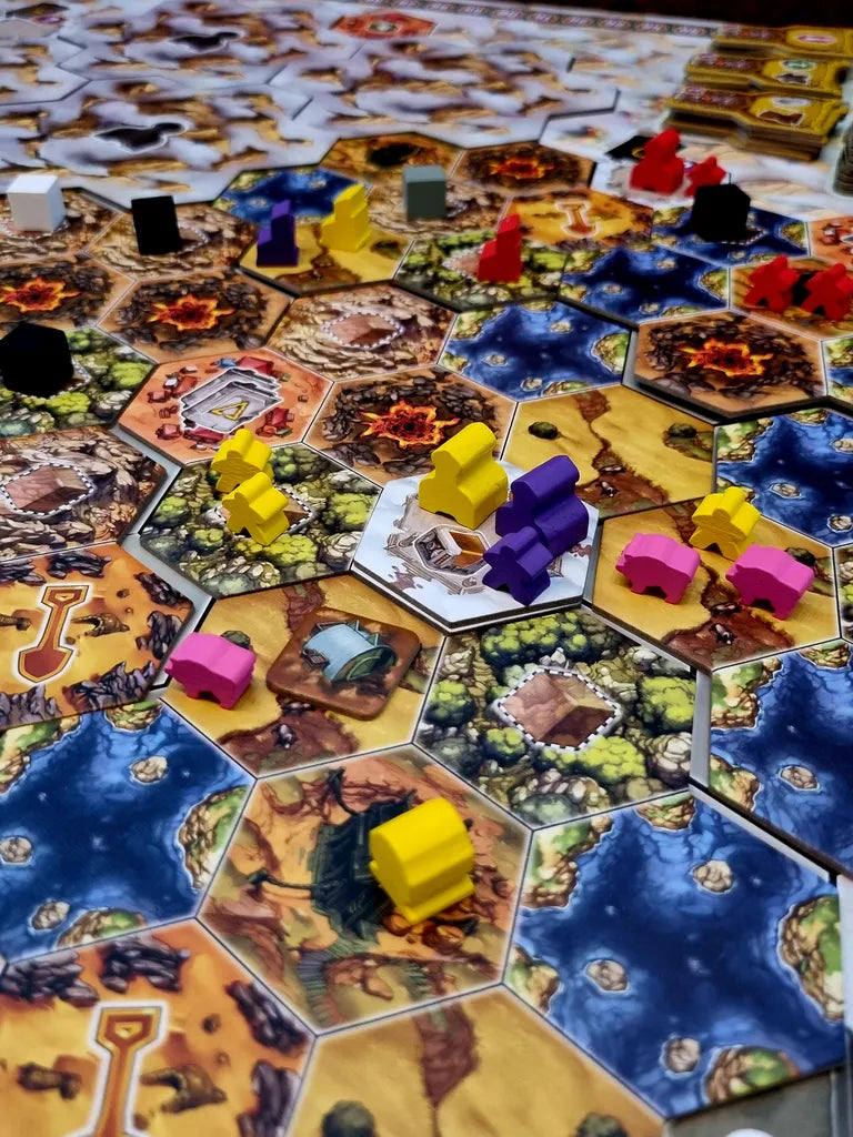 A close-up of Recall, a colorful strategy game by Alion Games, featuring hexagonal land and water tiles and animal-shaped wooden pieces in different colors representing tribes placed on the board.
