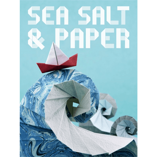 An origami red and white boat sails a blue swirled paper wave as "Sea Salt & Paper" from Bombyx, the bold set collection card game, appears in geometric white letters on a light blue background.