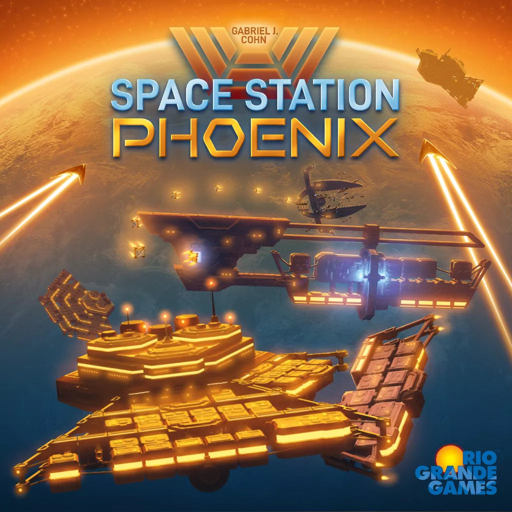Futuristic space stations orbit a glowing planet lit in orange and blue as beams shoot outward. The text “Space Station Phoenix” spotlights this epic board game by Rio Grande Games, with their logo shown in the corner.