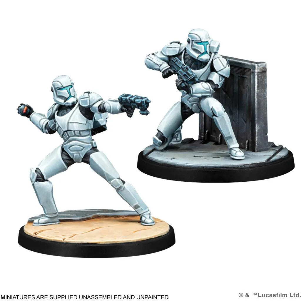 The Star Wars: Shatterpoint – Plans & Preparation Squad Pack by Atomic Mass Games features two unpainted Clone Commando miniatures in armored suits with helmets—one stands aiming a blaster on a tan base, the other crouches near a wall on black.