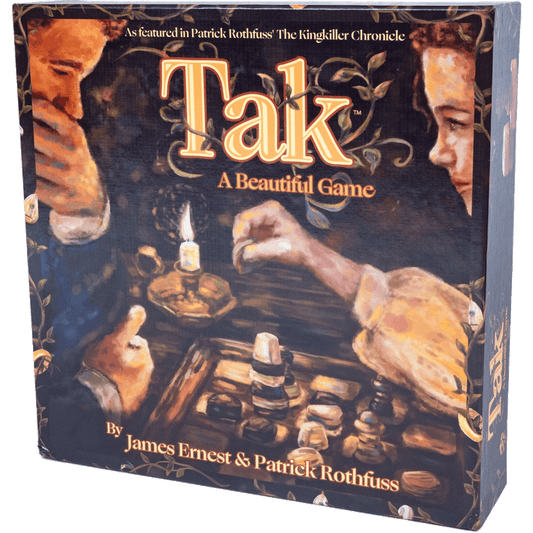 A board game box for Tak: A Beautiful Game by Greater Than Games, showing illustrated hands playing the strategy game with wooden pieces and a candle, plus text referencing The Kingkiller Chronicle.