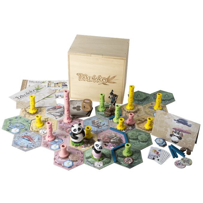 The Takenoko Giant Collector's Edition by Matagot features hexagonal tiles, panda and gardener figures, colored bamboo pieces, cards, tokens, instruction booklets, and a wooden storage box arranged on a white background.