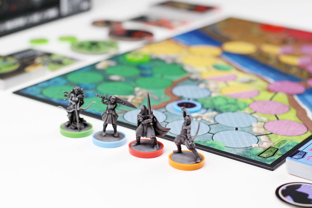 Four miniatures from Unmatched: Battle of Legends, Volume One (Iello) stand on colored bases beside a vivid game board filled with spaces, tokens, and cards—showcasing the dynamic action of this Iello miniature fighting game.