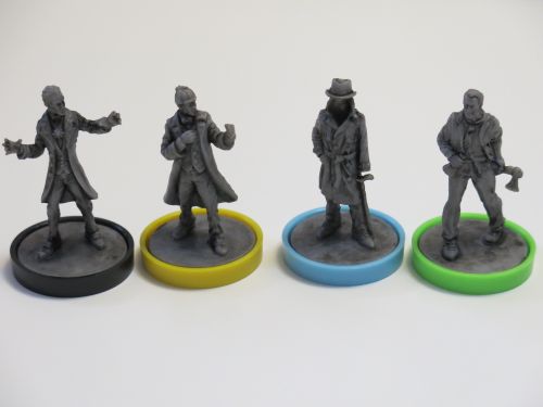 Four gray figurines from Unmatched: Cobble & Fog by Restoration Games stand on black, yellow, blue, and green bases. Each features unique attire and pose, representing different characters from this asymmetrical miniature fighting game.