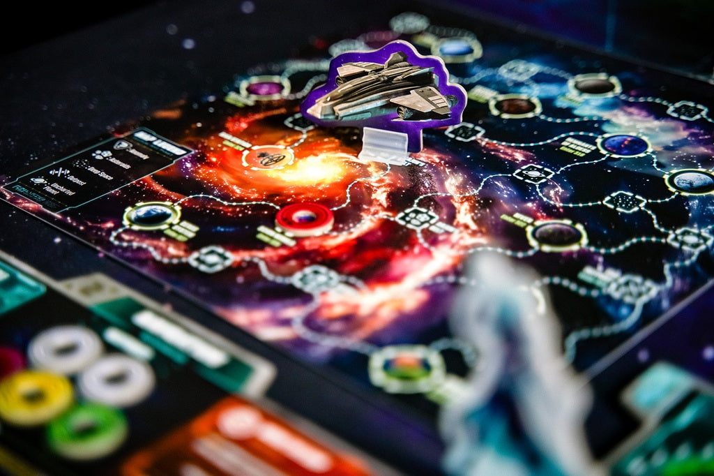 A close-up of Wandering Galaxy: A Crossroads Game by Plaid Hat Games, showing a cardboard spaceship on a vibrant, galaxy-themed board with colorful paths, tokens, and cards.