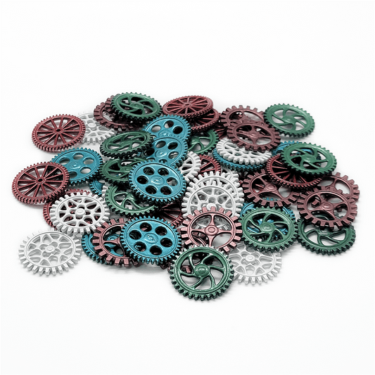 A pile of Weather Machine Metal Machine Parts by Eagle-Gryphon Games in green, red, and silver lies scattered on a white background. The assorted gears vary in size and design, with some having spokes and others solid centers.