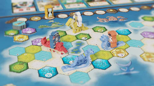 Wondrous Creatures by Bad Comet is a vibrant strategy board game with hexagonal land and water tiles, diverse sea creature and character figures, arranged game pieces, plus cards and tokens displayed at the top.