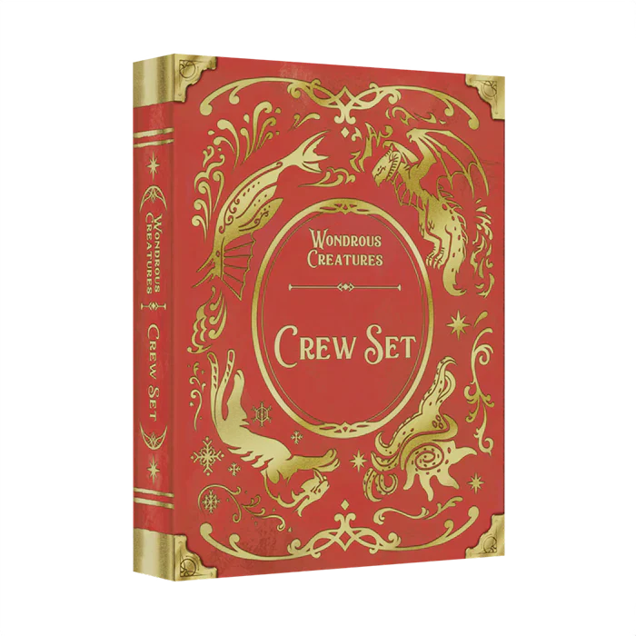 The Wondrous Creatures: Crew Set Expansion by Bad Comet is a red and gold hardcover book with ornate designs and illustrations of fantastical creatures, including a dragon and a bird, on the cover and spine.