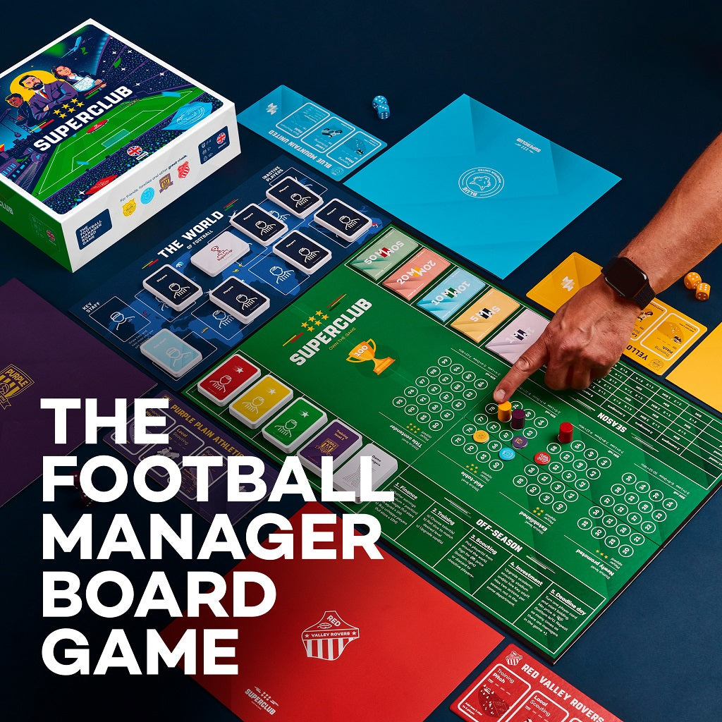 A person plays Superclub: The Football Manager Board Game by Superclub, featuring vibrant cards, dice, tokens, and a detailed green board. The box and components are shown on a dark surface with the text: THE FOOTBALL MANAGER BOARD GAME.