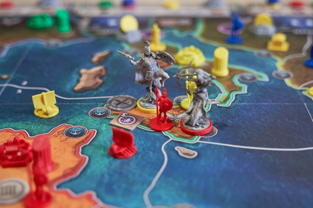 Board game with figurines and colorful pieces on a map