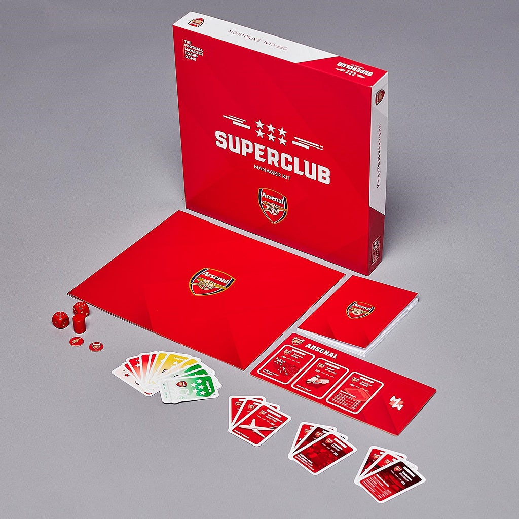 A photo of the Superclub: Arsenal Manager Kit by Superclub, showing the game box, cards, dice, folded board, and game pieces—ideal for any aspiring Arsenal manager—arranged neatly on a gray surface.