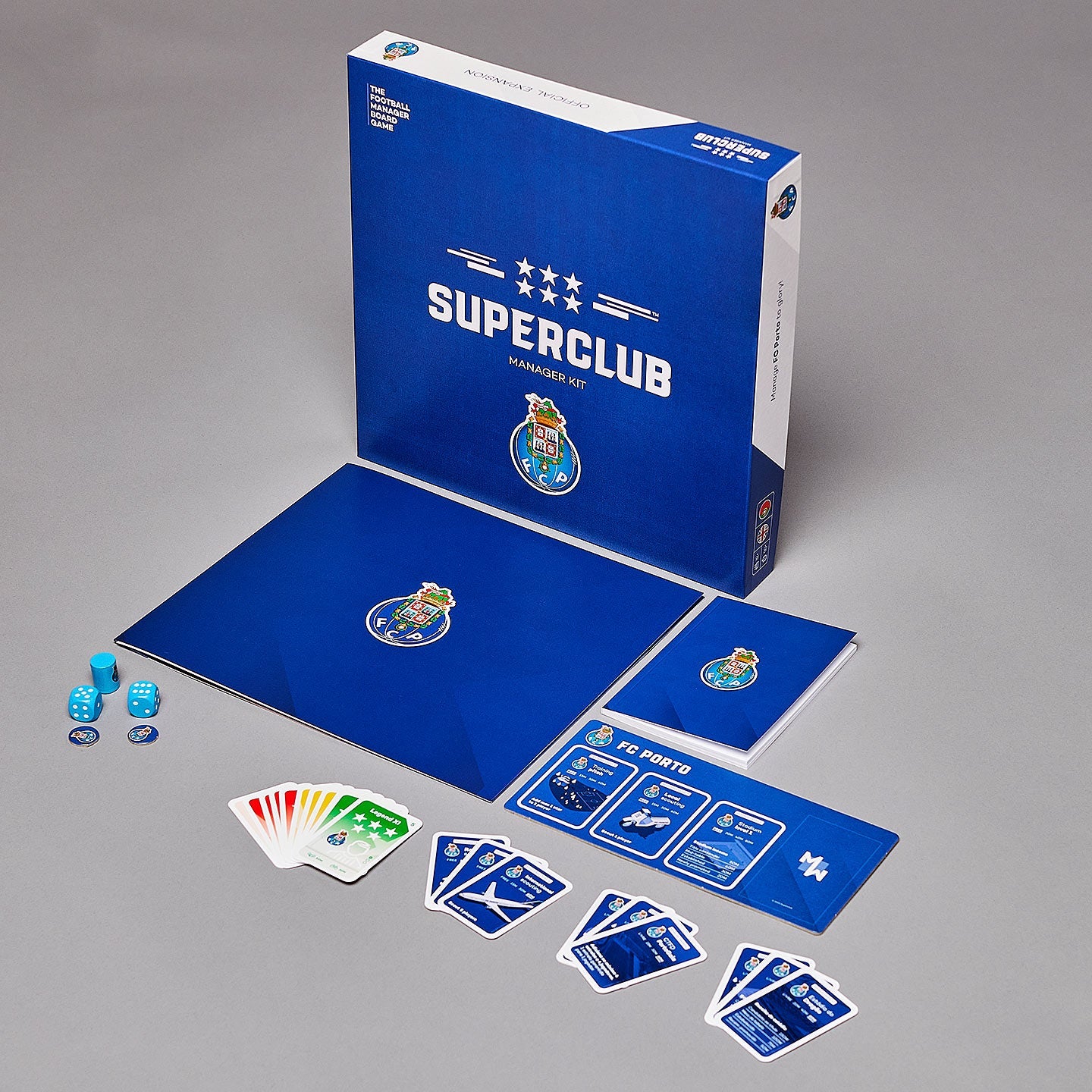 The Superclub: FC Porto Manager Kit by Superclub features a manager folder, game board, cards, dice, tokens, game box, and Superclub trophy—all showcased on a gray surface.