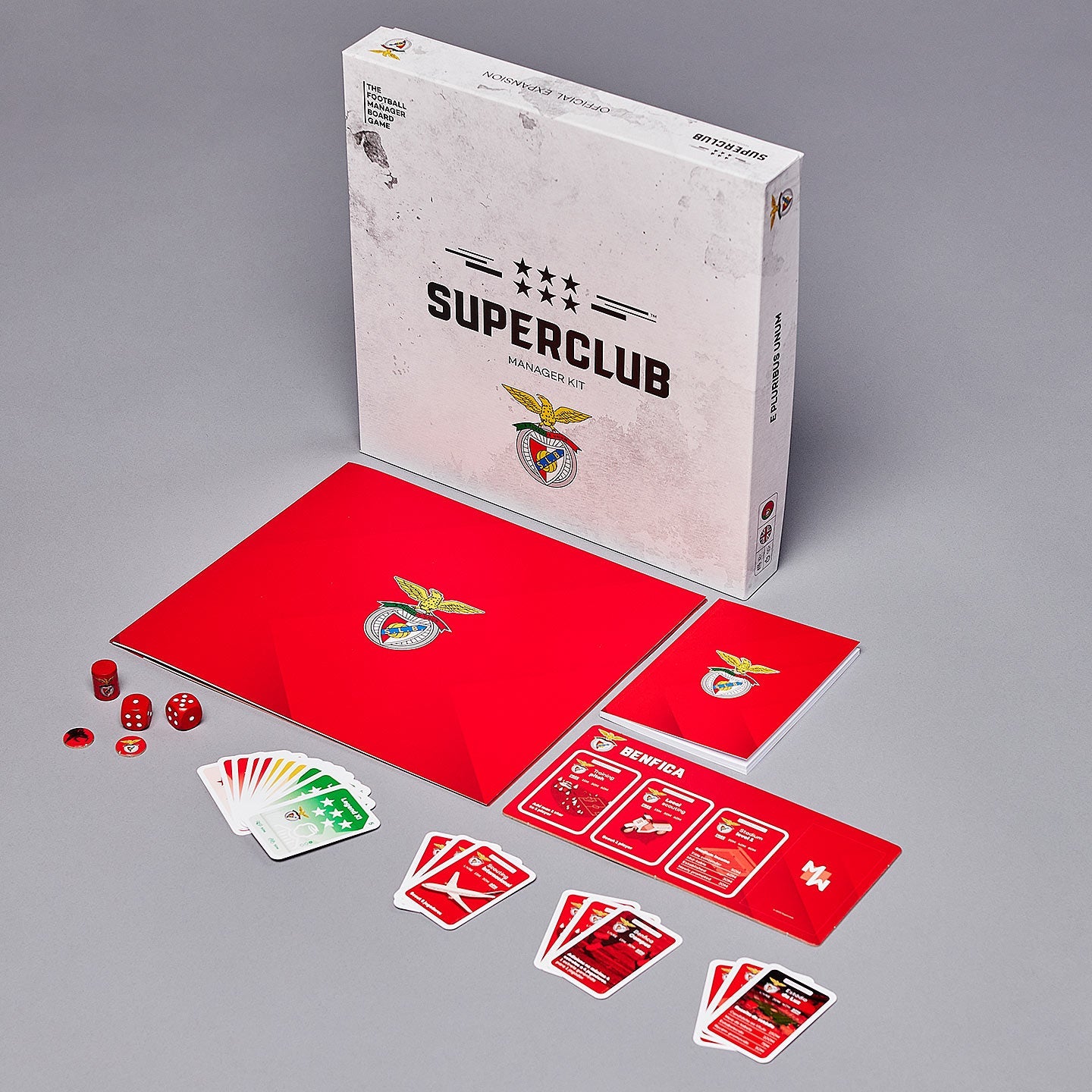 Superclub: SL Benfica Manager Kit by Superclub features a red game board, cards, dice, and tokens in a box themed after SL Benfica and Estádio da Luz, all arranged on a gray surface.